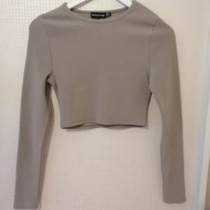 Beige croptop - Beige croptop från prettylittlething ganska "hård" i materialet