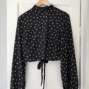 Topp med öppen rygg  - Prickig topp med öppen rygg. Prislappen borta men aldrig använda. Köpt för 349kr