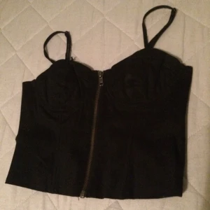  - En snygg svart sommar topp med gylf där fram! Tyvärr så är en av snörena på axeln av men man eller jag kan lätt fixa det!