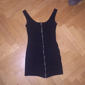  - Figurformad klänning med dragkedja. 
