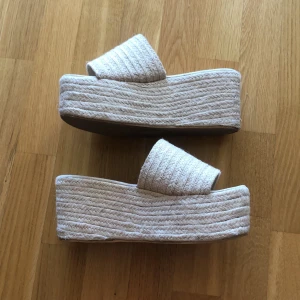 Tofflor med hög sula från NLY shoes - Supersnygga tofflor köpta på Nelly förra sommaren, men som aldrig kommer till användning. Använda vid ett tillfälle, inomhus, så skorna är i riktigt fint skick! 🌸Kan mötas upp i sthlm, annars står köparen för frakt (60kr)🌸