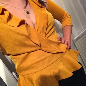 Gul topp med volang - Mycket söt gul topp med volang och 3/4 ärmar. Från Nelly och deras egna märke NLY TREND. Använd en gång. 80kr + frakt.