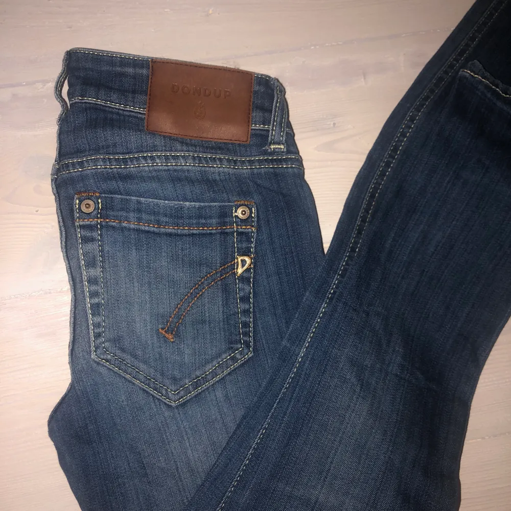 Ett par jätte fina DONDUP jeans i storlek 25, från Italien. Byxorna är blåa, med en slitning på båda ben. Byxorna sitter ganska tajt men är riktigt fina på. Jag säljer byxorna för att jag har växt ur dom, nypris ligger på 3000kr ca. Väldigt fin kvalitet!. Jeans & Byxor.