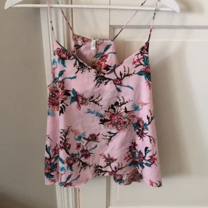 Sommarlinne strl 34 - Säljer detta rosablommiga sommarlinnet från nelly, den är i storlek 34. Den är ej genomskinlig och är i ett luftigt material. Hör av dig om intresserad!