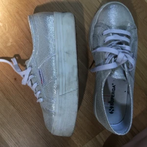 Skor Superga - Glittriga skor från Superga med hög sula som är använda ett fåtal gånger. Storlek 37. Priset går att diskutera och köparen står för frakten!