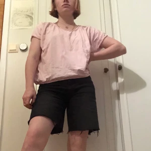 Babyrosa T-shirt - En rosa T-shirt med knappar på ryggen som inte går att knäppa upp. Den är en XL men passar M-XL.