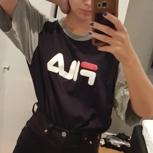Fila t-shirt stl XL - Svart/grå t-shirt från fila med rött/vitt fila märke. Stl XL, oversized på mig. Den är sparsamt använd och mycket fint skick. Frakt tillkommer (50 kr). Äe det flera intresserade blir det budgivning😊