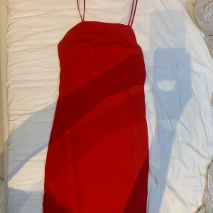 Röd kläning - Röd klänging med tunna spagettiband, även dubbla lager tyg. Budgivning från 50kr