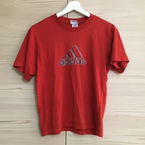 Adidas t-shirt - Röd/orange adidas t-shirt i strl 140 men passar som en XS/S 😄👍 Den har ett litet hål på kragen (bild 3) men jag skulle inte säga att det är något som märks. Köparen står för frakt som ligger på 44kr! Pris kan diskuteras:)