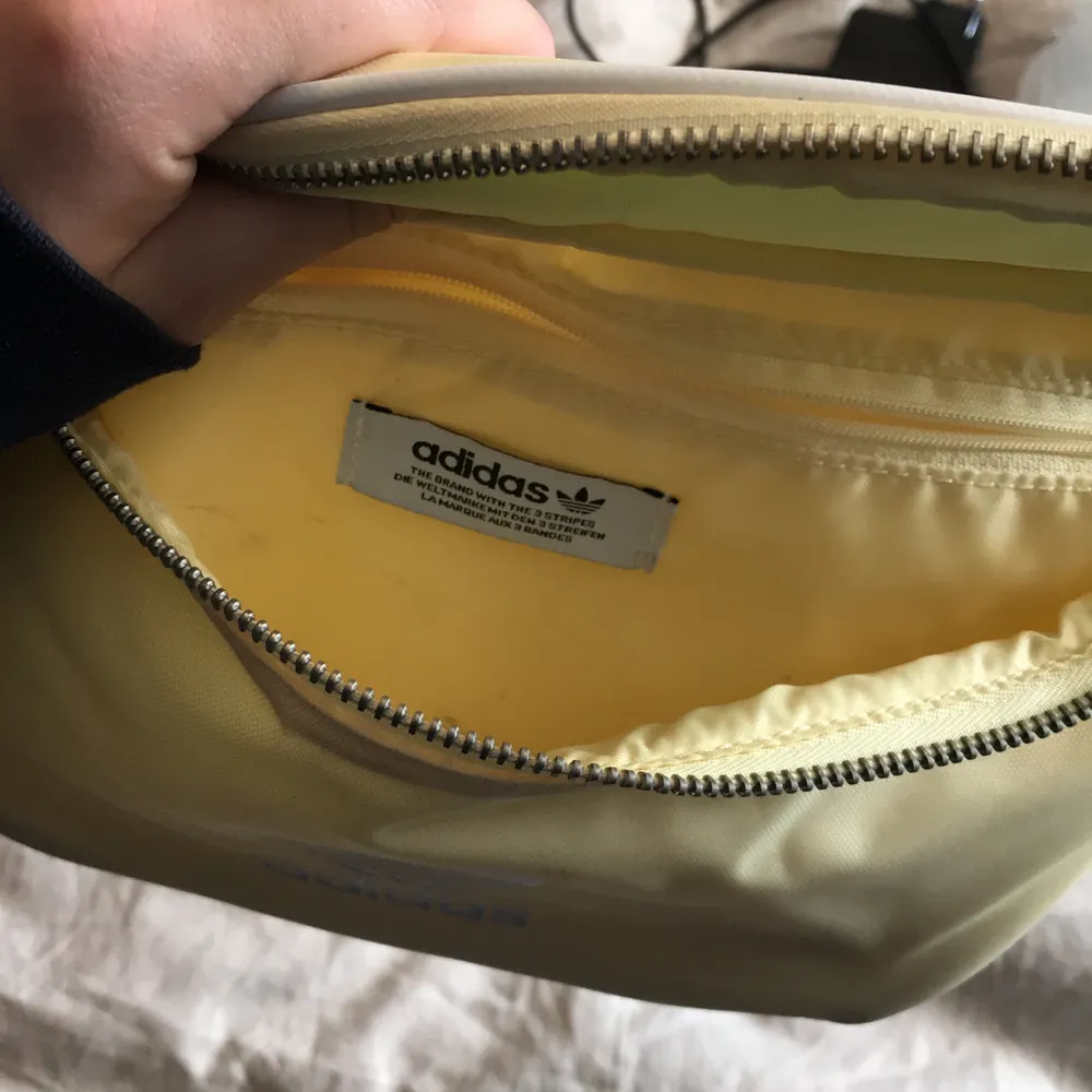 gul magväska från adidas, lite smutsig inuti men inget som syns och går nog att torka bort. . Väskor.