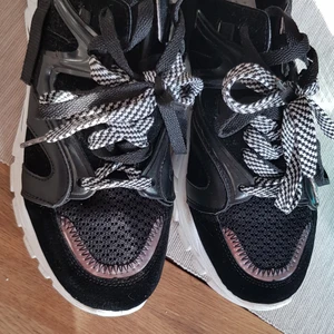 Sneakers knappt använda  - Sneakers i svart och vitt med detaljer i svart lack. Kraftig sula. Strl 41