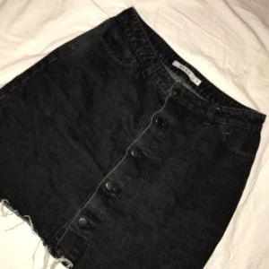 Svart Jeanskjol  - Säljer denna svart jeanskjol med knappar från NA-KD då den är mycket stor för mig. Kan mötas vid frakt står köparen för kostnaden.