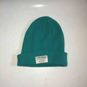  - Grönblå mössa som är ribbad. Använt en gång då färgen inte riktigt passade mig. Köparen står för frakt. Annars kan jag mötas upp i Stockholm.