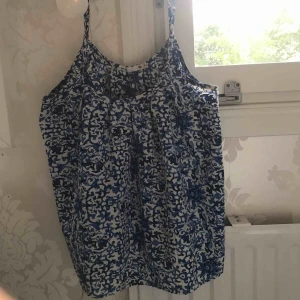  - Ett jättegulligt linne med blått mönster på. Frakt tillkommer, alltså det betalas av köparen.