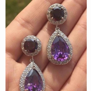 - Säljer nu dessa helt nya eleganta örhängena. Ametist Lila med klara stenar runt om i cubic zirkonia Längd: 3,6 x 1,5 cm Originalpris : säljes för ca 299-499:- beroende på vilken bröllops och festklänningsbutik  