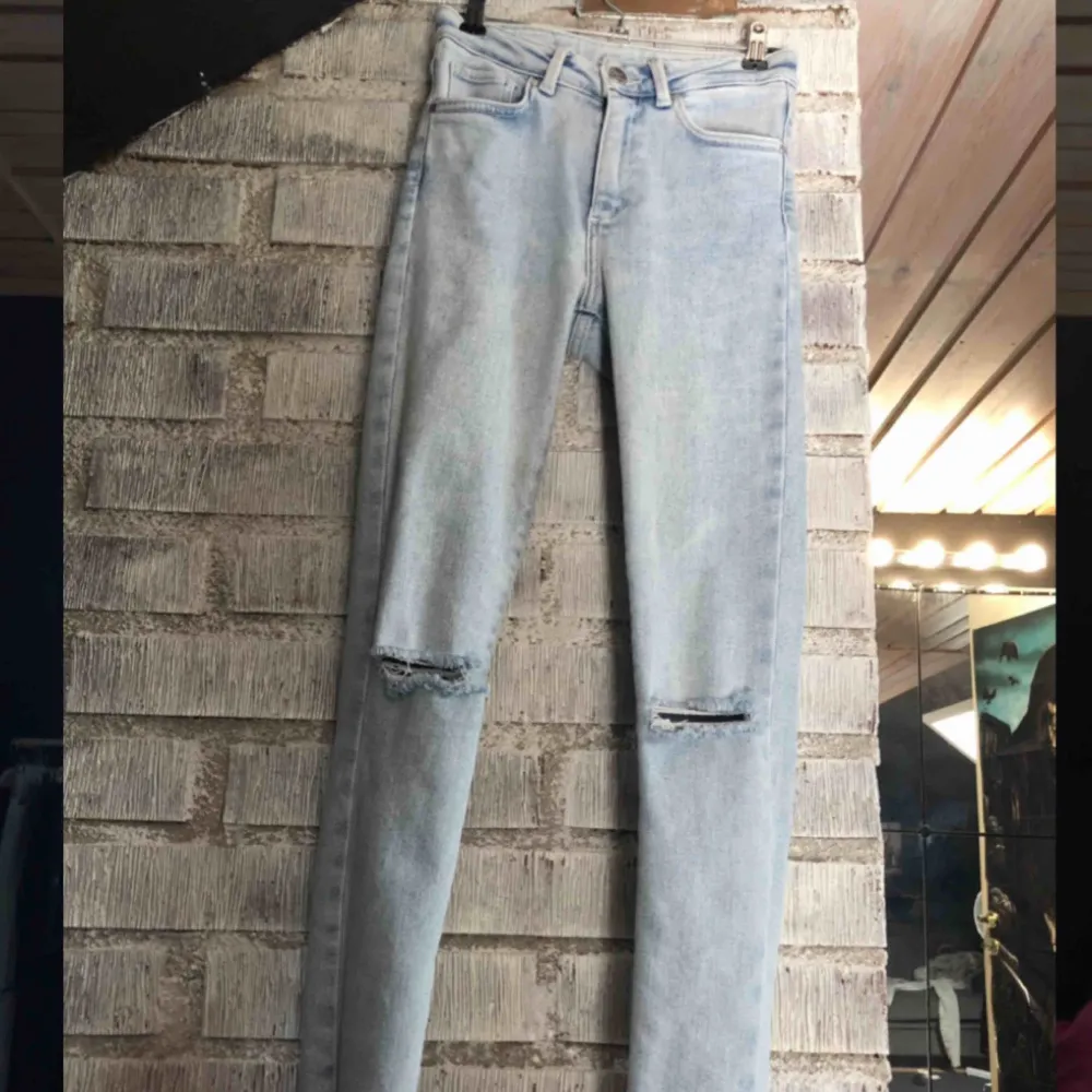 Skitsnygga ljusblå jeans från Bikbok. Hål i knäna, slitna detaljer längst ner vid fötterna, sitter perfekt. Säljer pga att de aldrig kommer till användning. Nypris 599kr.. Jeans & Byxor.