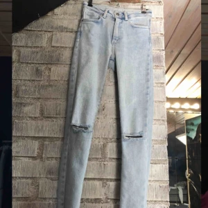 - Skitsnygga ljusblå jeans från Bikbok. Hål i knäna, slitna detaljer längst ner vid fötterna, sitter perfekt. Säljer pga att de aldrig kommer till användning. Nypris 599kr.