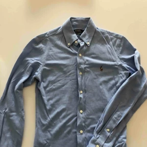  - Ljusblå knit Oxford från RL i slim fit. Använd ett fåtal gånger och är i nyskick. Hämtas i Malmö eller skickas mot frakt.