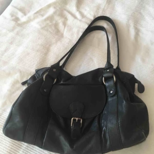  - Svart väska i skinn köpt för ca 10 år sen på Åhléns. Bra skick men en innerficka är trasig. Dock inget som stör. 