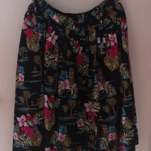Kjol från hell bunny  - Säljer min kjol från hellbunny som endast är provad och passa inte mig. Snyggt mönster med plamer, papegoja och hibiskus. Kjolen har fickor. 
