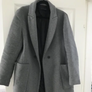 Kappa från Zara i ull - Grå, herrrocks modell. Använd men i bra skick. Mindre i storleken så passar S/M (jag har 38) trots att det står L. Köpt för 1200kr för 1-2 år sen. Kan gå ner i precis vid snabb affär. Köparen står för frakt.