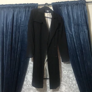 Vår/höst kappa i svart tyg - Rensa garderoben och såg denna finna kappa, säljer bort den då jag inte använder den och tänkte sälja den till någon som har den till någon användning. Kappan är använd men är i bra skick, köparen står för frakten🥰