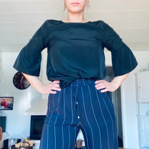 Svart topp - Svart topp med volanger i ärmarna. Använd några gånger men i jättefint skick. GRATIS FRAKT🦋