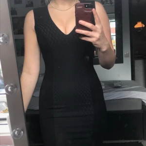 Svart klänning med öppen rygg.  - Svart klänning med ormmönster. Väldigt stretchig! 