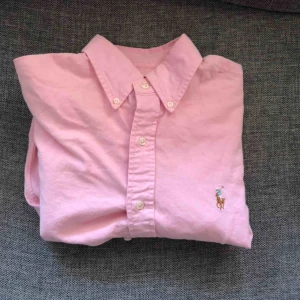  - Rosa Ralph Lauren skjorta, inköpt på NK i Göteborg.  Modell: Oxford Stretch, Slim fit  Storlek: S  Kan skickas inrikes i Sverige eller lämnas över i Göteborgsområdet utan kostnad.