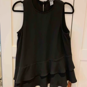  - Topp från HM med volangkant nedtill, snedskuren.