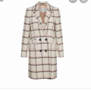 Rutig kappa - Jätte snygg och stilren rutig kappa från InWear. Nypris 2200kr. Använd några få gånger så den är i väldigt fint skick. Går att knäppa med två stycken knappt utan på och har två stor fickor.Den är beige med rosa, gråa rutmönster.