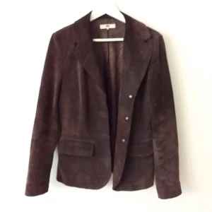  - 100 % läder och 100 % polyester lining. En second hand kavaj med 3 knappar. 