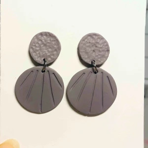  - Handgjorda örhängen i lera. Färgen är en superfin och unik blandning av lila, grå och brun. Nickelfria. Jag bjuder på frakten🥰