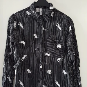  - Svart skjorta med katter på i jättefint skick. Storlek XS men tror den passar S med. Kan skickas om köparen står för frakten som blir 36kr.