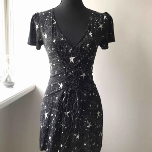  - Kort klänning med månar och stjärnor som motiv. Reglerbar, diskret snörning framtill och dragkedja baktill. Endast använd vid ett tillfälle så i nyskick! Köparen står för frakten 🌙✨