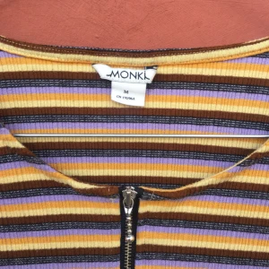  - Top från Monki med dragkedja. Ribbat tyg som är i stretch. Lite kortare i modellen. Sparsamt använd.
