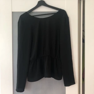  - Sjukt snygg och skön blus med resår i midjan och djup urringning i ryggen. Perfekt till fest. Svart och tunn och sitter sjukt snyggt