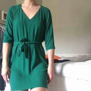  - Klänning har strl L men passar M och liten L. Fin grön färg och bandet är avtagbart. Kommer från ett djur-och rökfritt hem.  Fraktar gärna och köparen står för fraktkostnad.