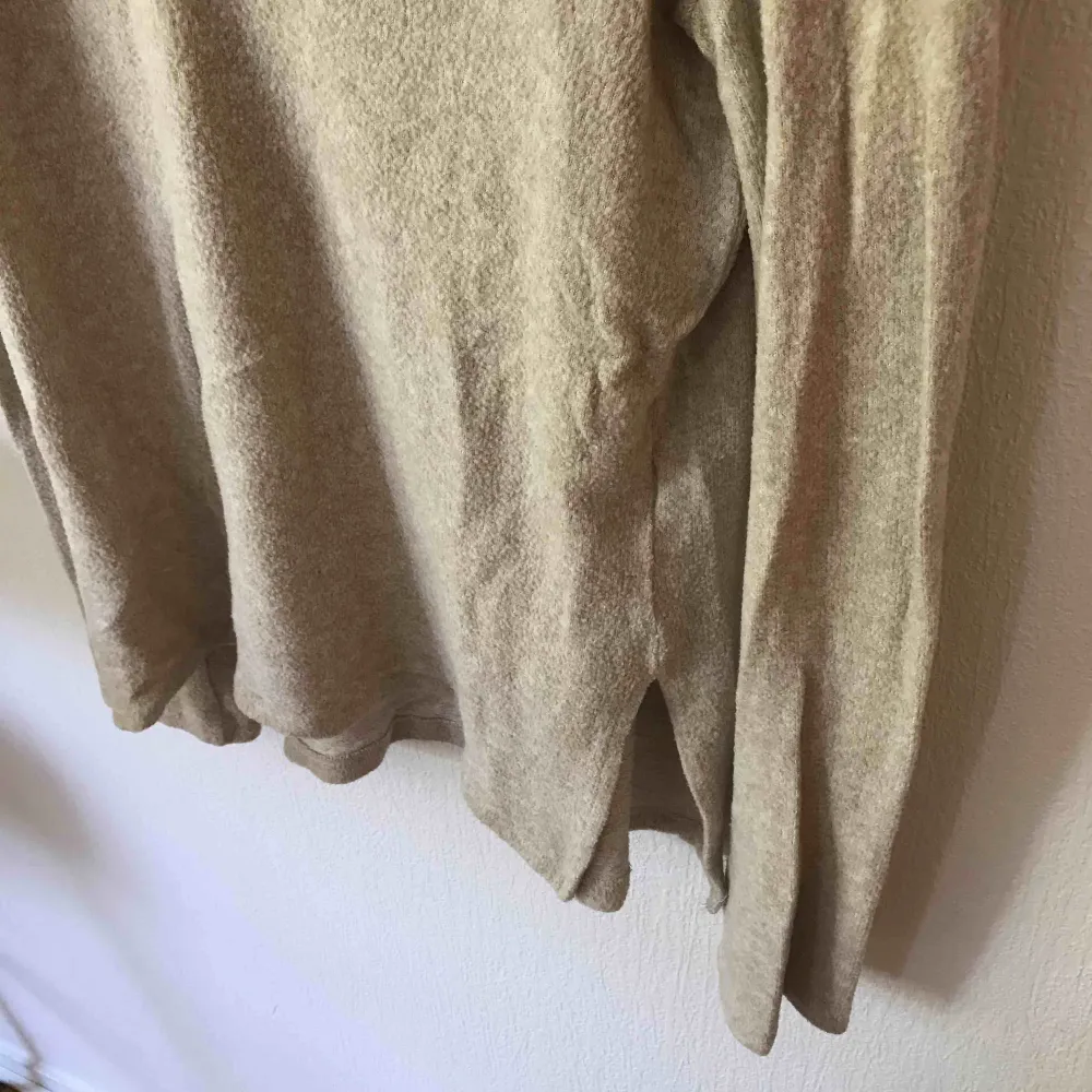 Långärmad tröja från BikBok i färgen beige. Mycket mjukt material. V-ringad och längre bak än fram. Vid köp tillkommer fraktkostnad.. Tröjor & Koftor.