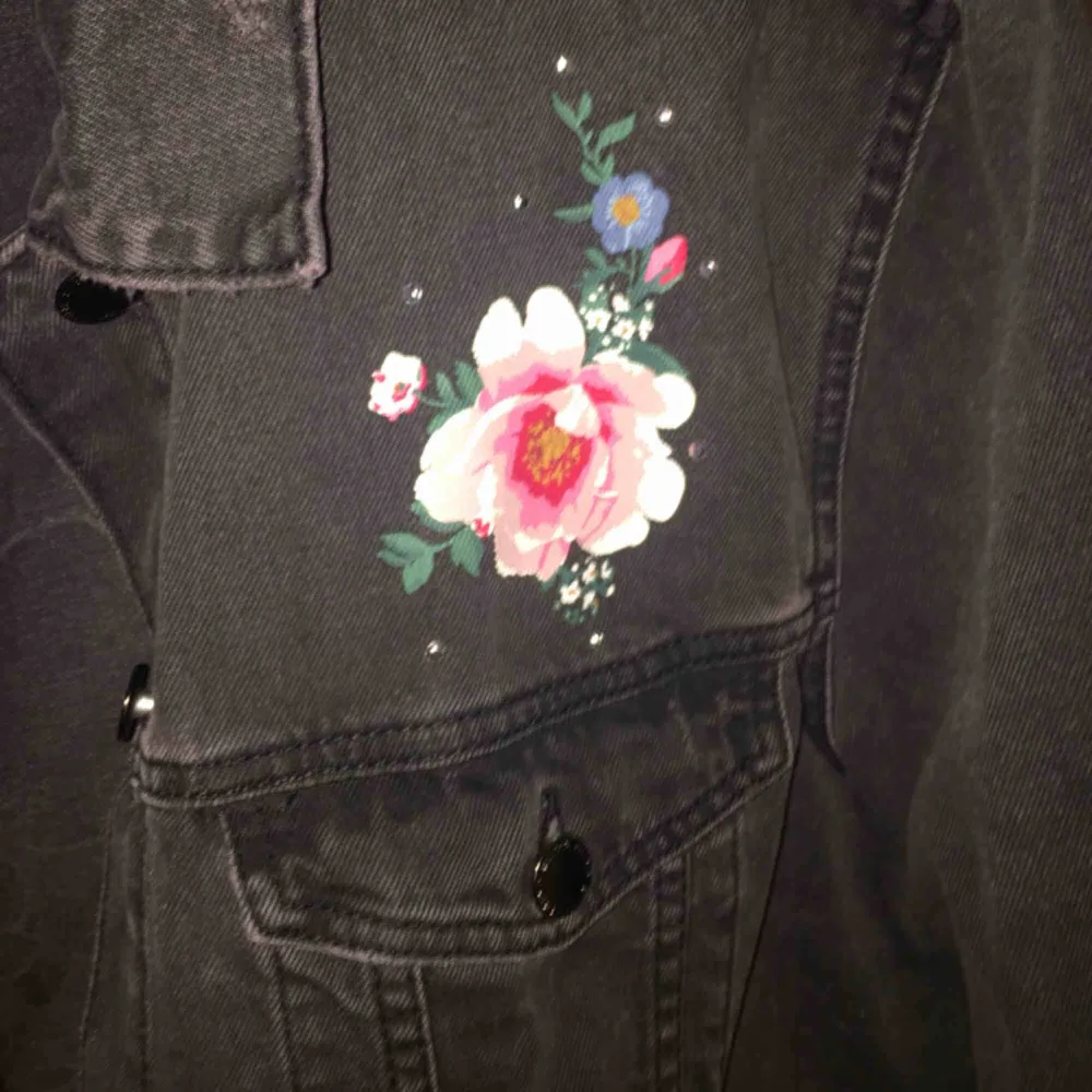 En svart jeansjacka med rosor och lite pärlor på! den är från HM och är aldrig använd. För mig som brukar ha S så är det som en oversize jacka, perfekt till våren! Säljer den för att den inte kommer till användning. Frakten betalar köparen. Jackor.