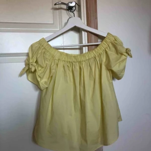  - Gul offshoulder topp med knutdetaljer på ärmarna. Färgen är mest rättfärdigad på första bilden. Sparsamt använd. 