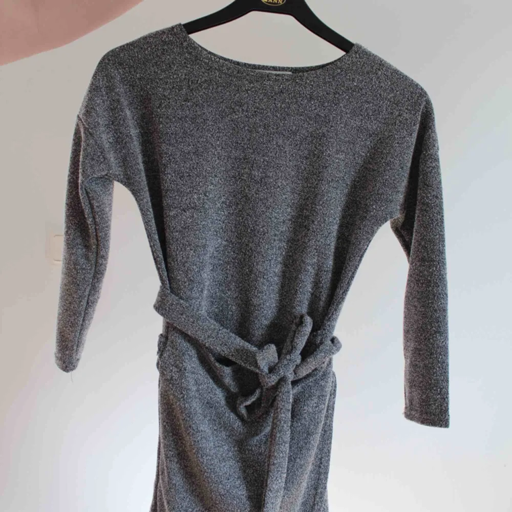 Cool grå klänning som man kan knyta omlott. Säljer pga har blivit för liten, annars knappt använd. Ärmarna är trekvarts ärm. Klänningar.