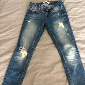  - Jeans från GT. Slitningar och dragkedja vid benslut. 