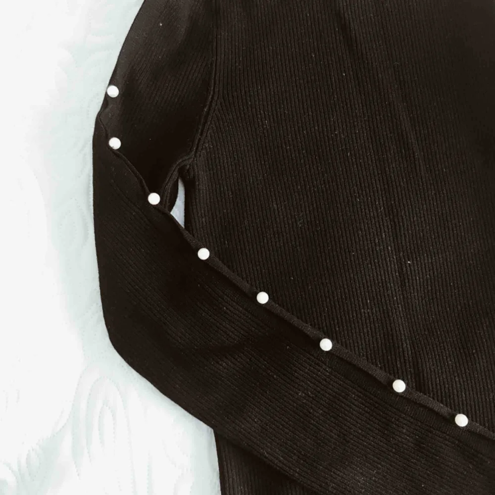 Stickad tröja från Zara med pärlor längst ärmen, endast använd en gång. Storlek M men passar XS/S.. Toppar.