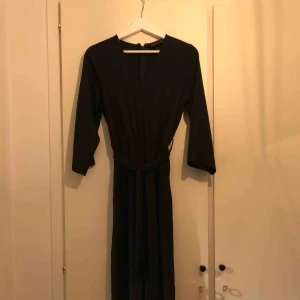  - Svart jumpsuit från Monki. Använd en gång. Knytskärp i midjan och vida ben nertill. Superskön men passar även till fest då materialet är lite tjockare och något glansigt.