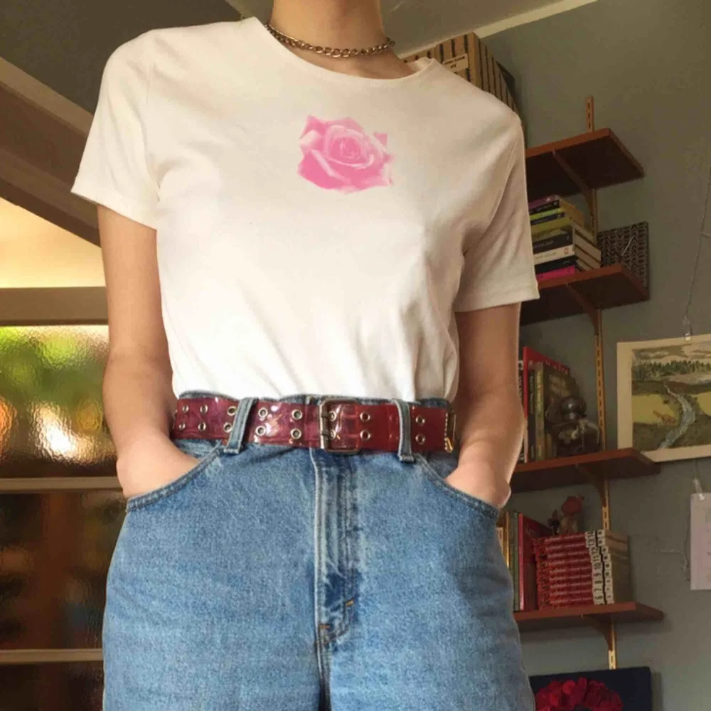 supersöt vit tshirt med rosa ros-tryck ! märkt med storlek 42/44, passar typ som en babytee på en L men är också snygg som oversized på mindre storlekar! frakt tillkommer. T-shirts.