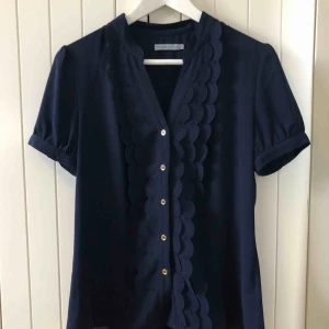  - Marinblå blus från Soaked in Luxury, endast använd ett fåtal gånger.  Nyskick!   Material 100% Polyester   Upphämtning i centrala Uppsala Porto tillkommer vid frakt, 36kr