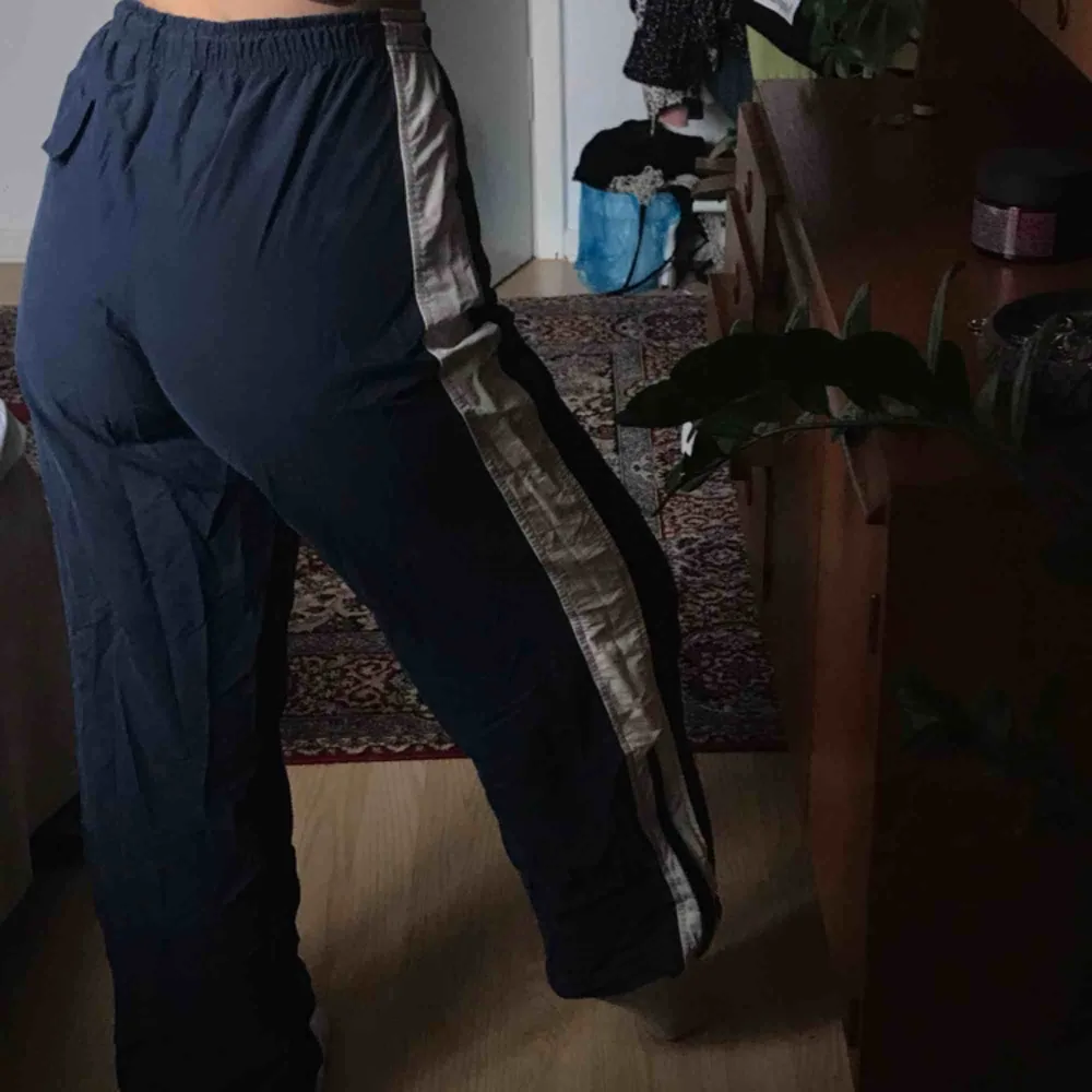 Supernsnygga trackpants i mörkblått och med vita ränder på sidorna. Materialet är vindjacksaktigt men supersköna!! . Jeans & Byxor.