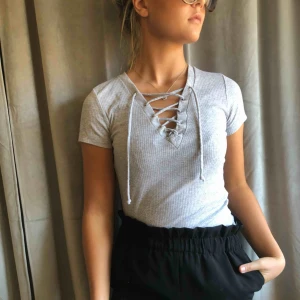  - Grå T-shirt med knyte vid bröstet! Från bikbok. Köparen står för frakten!