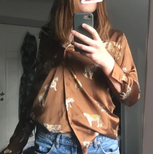 Zara skjorta - En jätte fin Zara skjorta/blus i ett material liknande siden. Köpt för cirka två månader sedan och superfint tryck, säljer då den inte kommit till användning. 💞💞 strl xs men sitter bra på mig som är en m!
